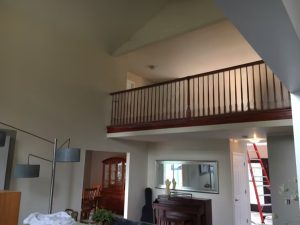Living room featuring a staircase leading to a balcony, showcasing a spacious and inviting atmosphere.