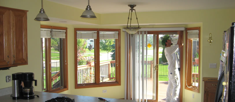 A man carefully painting the walls of a kitchen, showcasing his focus and creativity in home improvement.