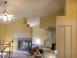 A cozy room featuring yellow walls and a charming fireplace, creating a warm and inviting atmosphere.